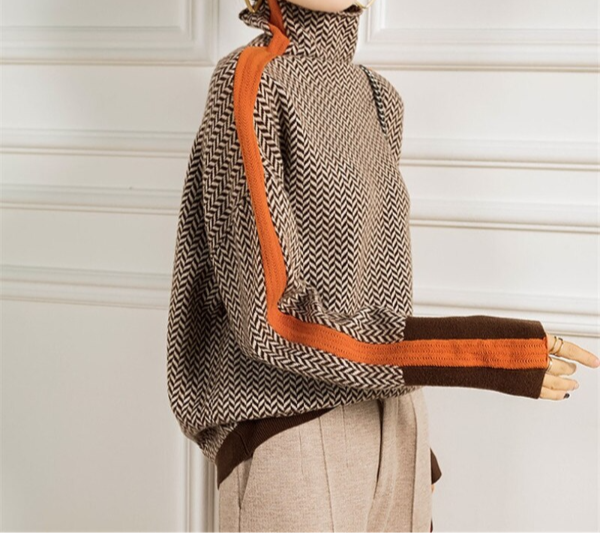 Mannequin wearing a patterned poncho with orange accents against a white background