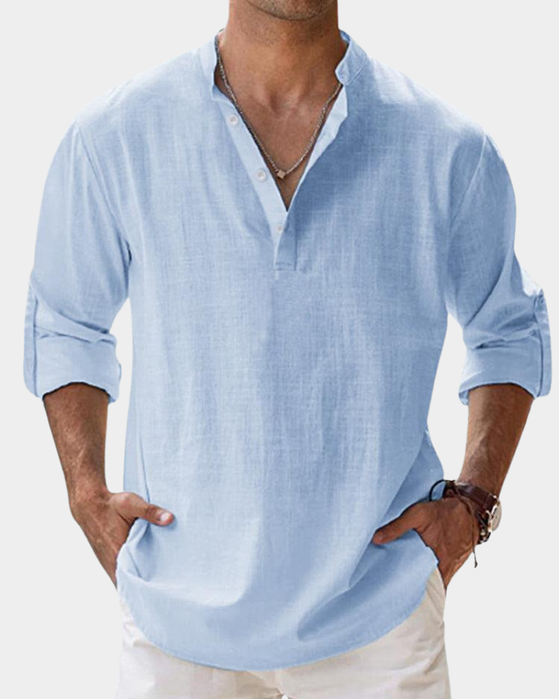 Man wearing a light blue shirt with rolled-up sleeves on a white background