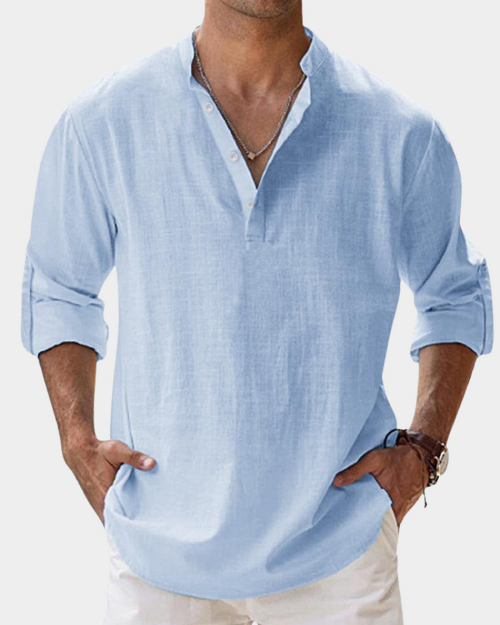 Man wearing a light blue shirt with rolled-up sleeves on a white background