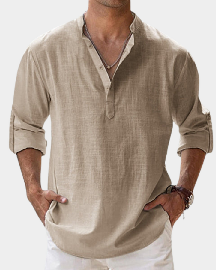 Man wearing a beige long-sleeve shirt with rolled-up sleeves on a white background