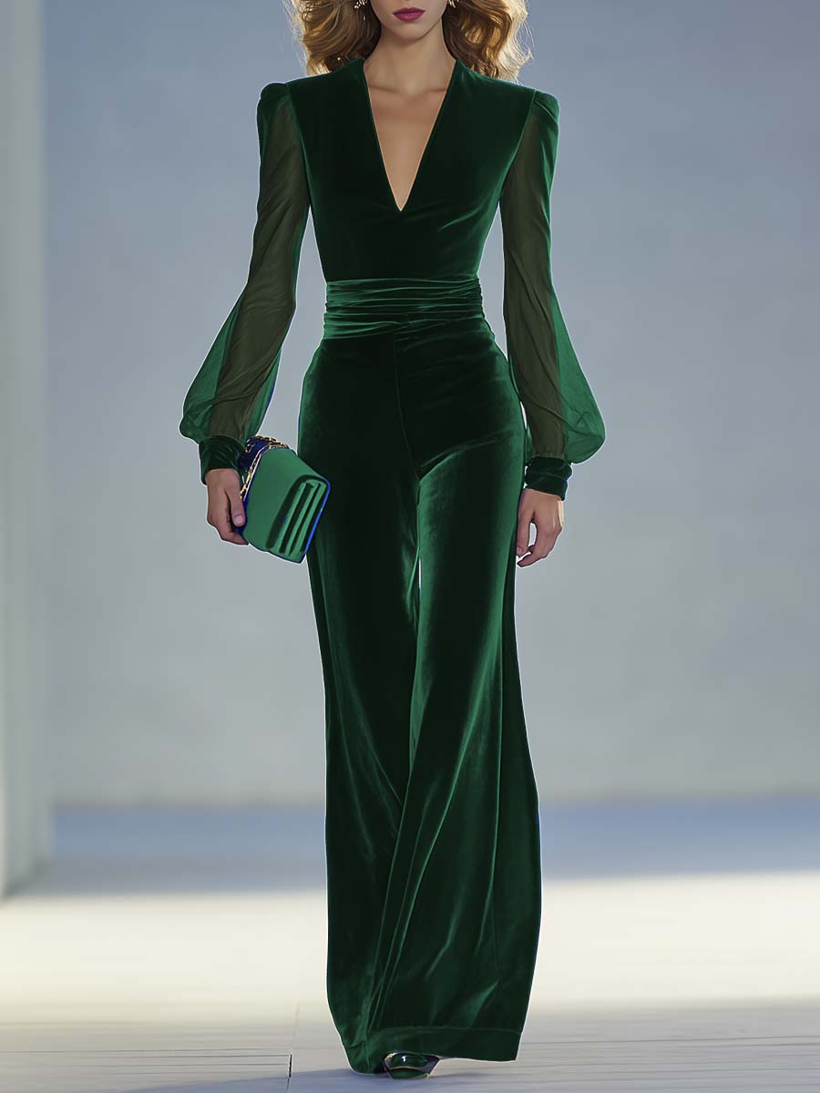 Green velvet evening gown with sheer sleeves on a neutral background