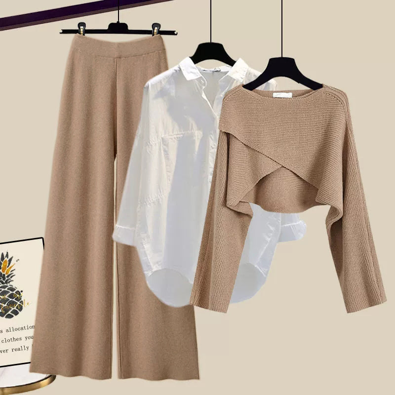 Brown pants and sweater set on hangers against a beige background