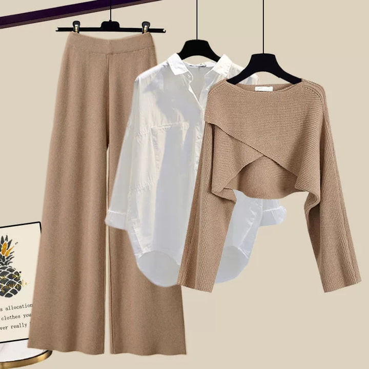 Brown pants and sweater set on hangers against a beige background