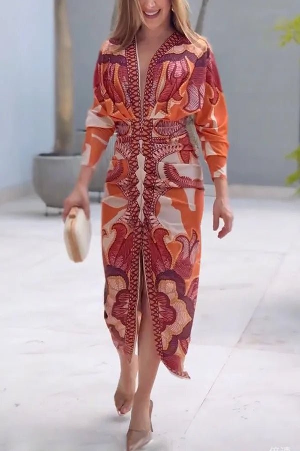 Woman wearing a patterned orange and red dress in an outdoor setting.