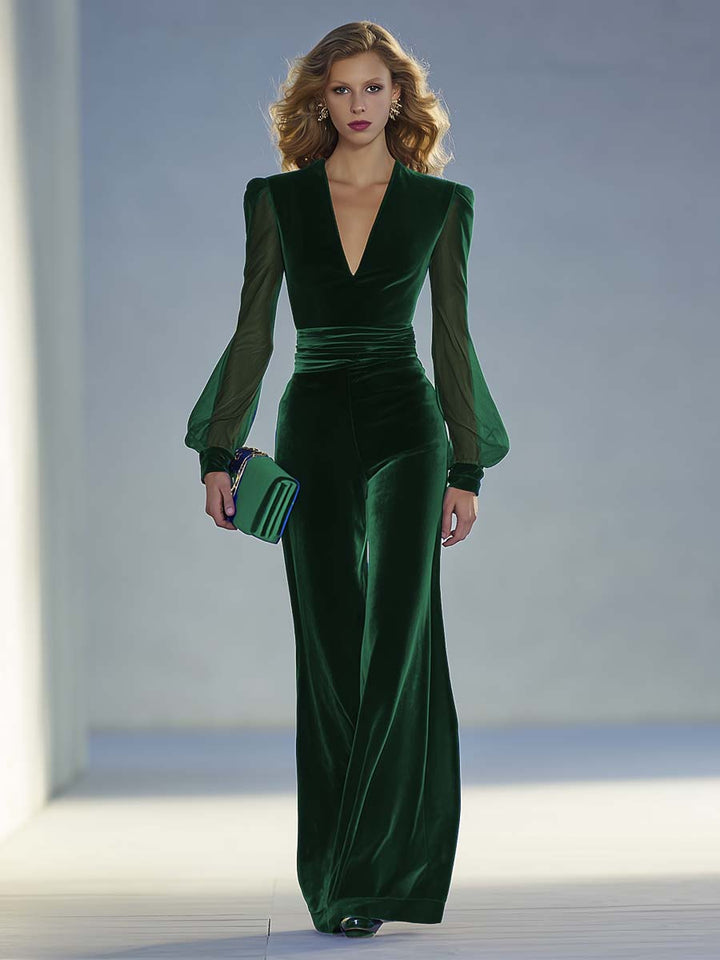 Green velvet evening gown with sheer sleeves on a neutral background
