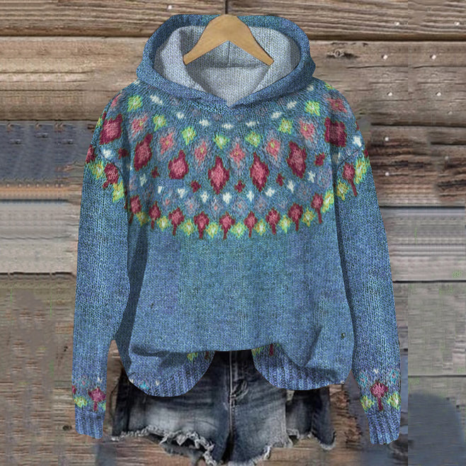 Blue knitted hoodie with colorful patterns on a wooden background