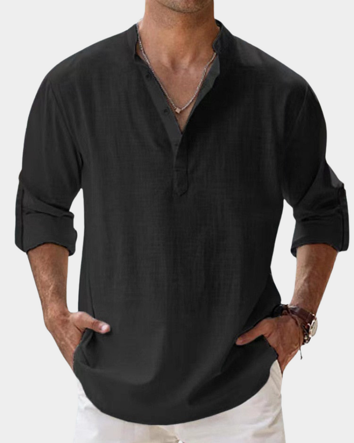 Man wearing a black long-sleeve shirt with rolled-up sleeves on a white background