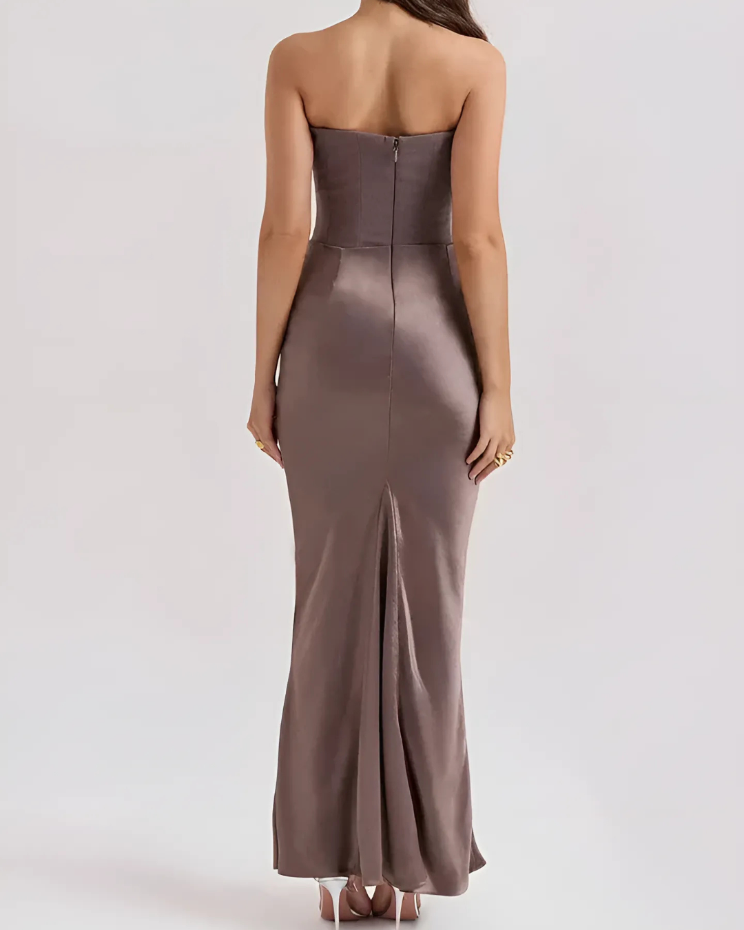 Woman wearing a strapless brown evening gown on a white background