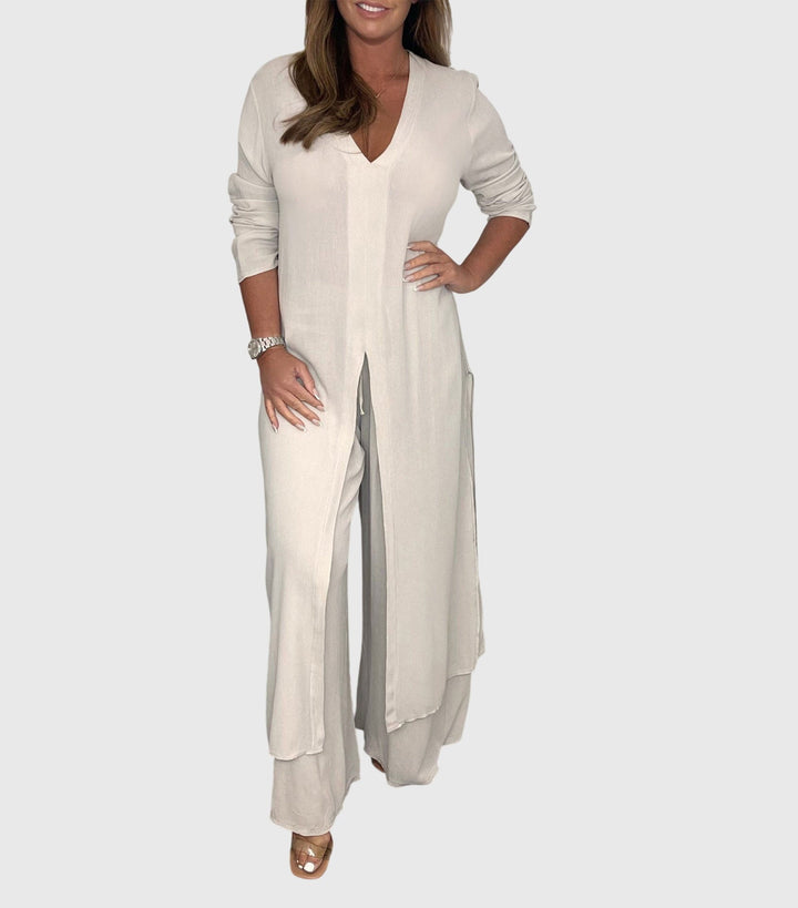 Woman wearing a beige outfit with a long cardigan and wide-leg pants on a white background