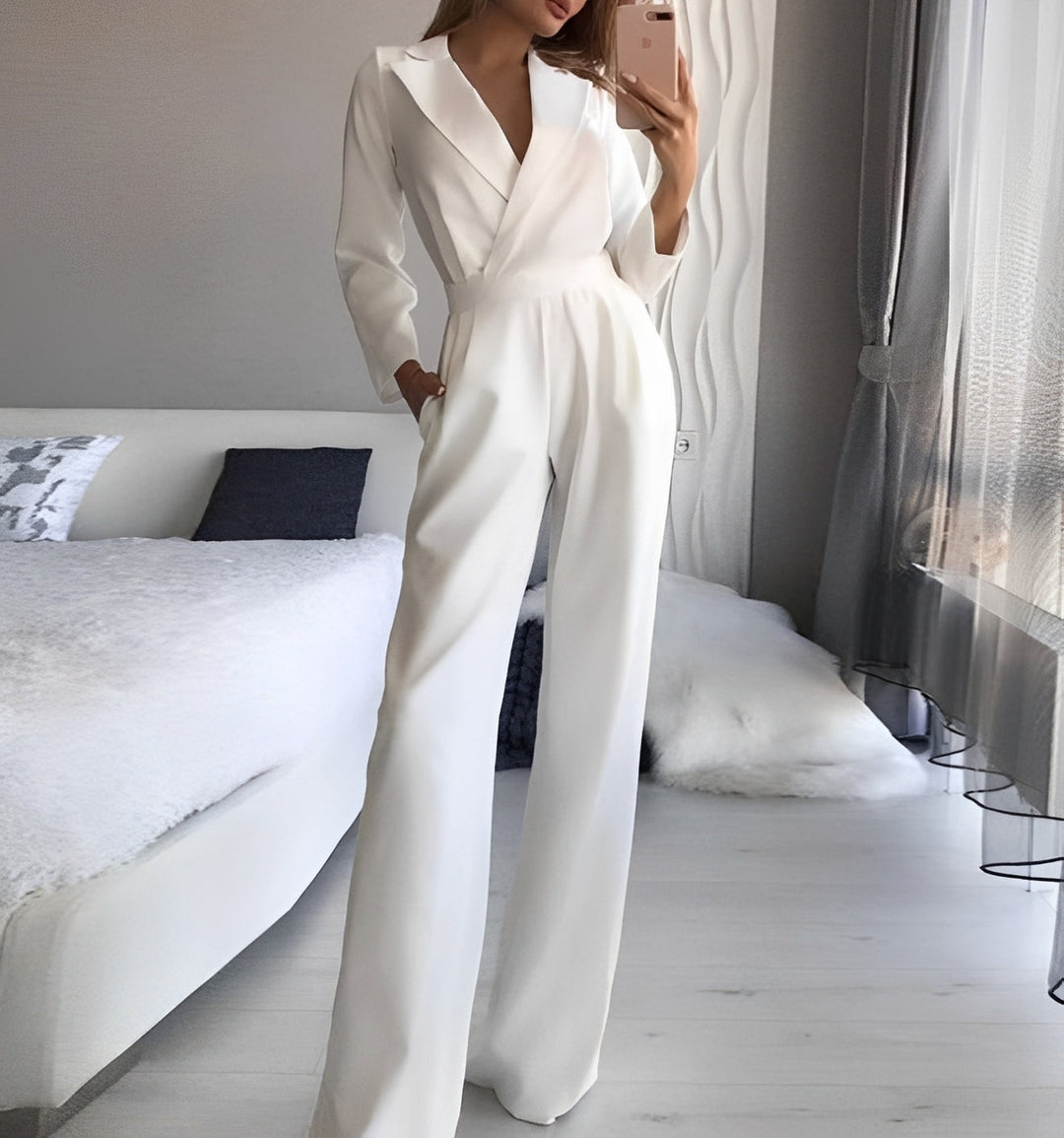 Person wearing a white jumpsuit in a bedroom setting