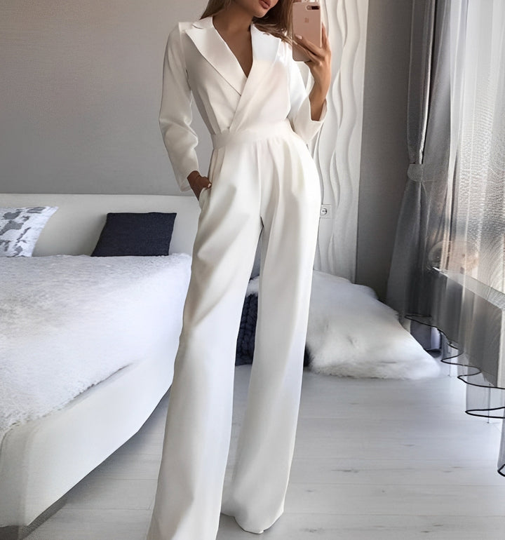 Person wearing a white jumpsuit in a bedroom setting