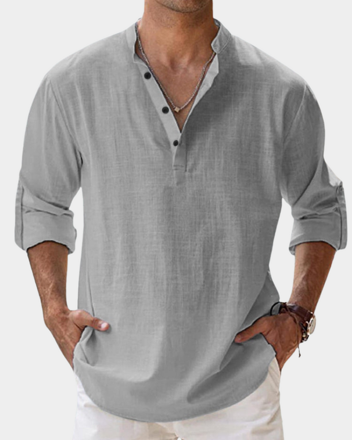 Man wearing a gray long-sleeve shirt with rolled-up sleeves on a white background