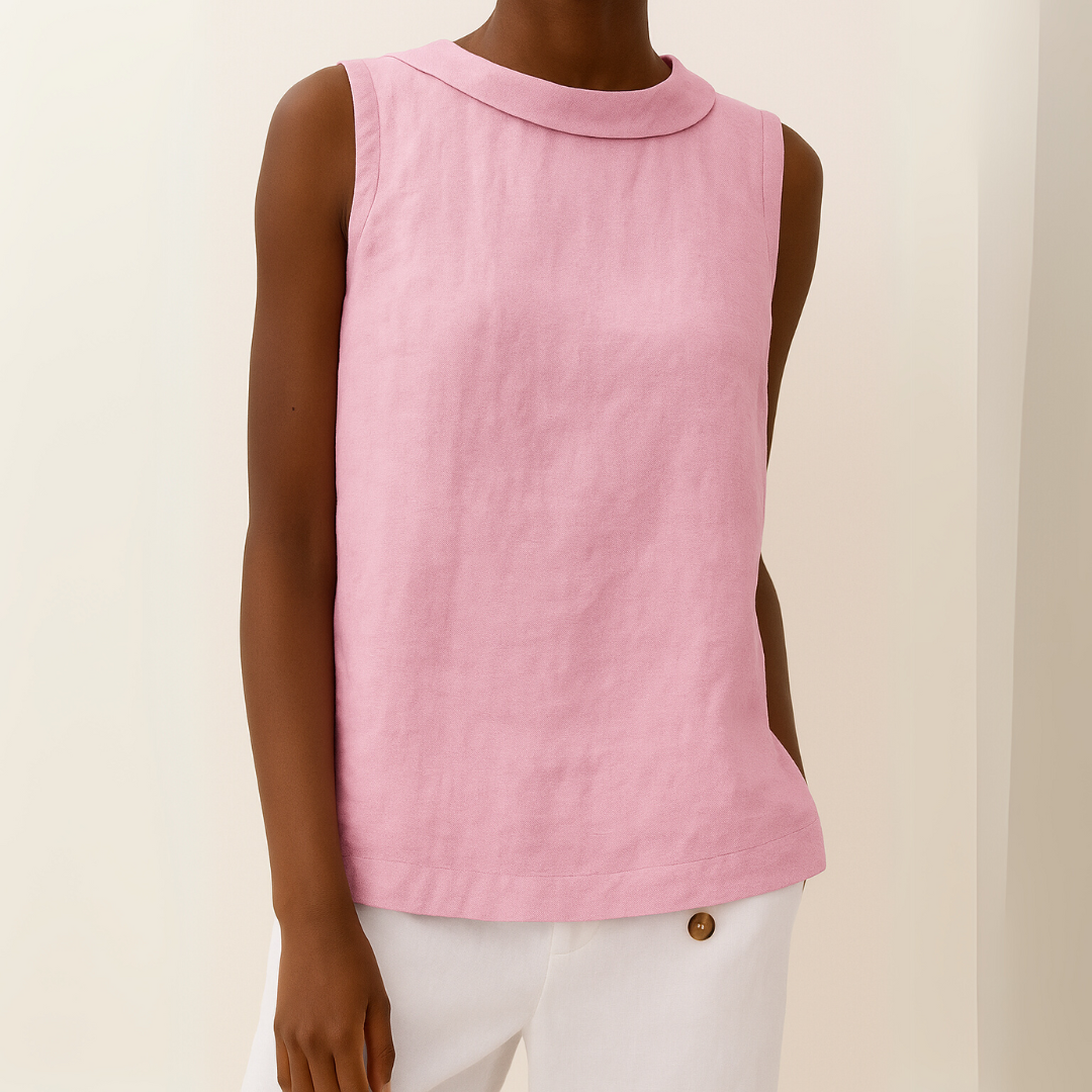 Person wearing a pink sleeveless top with a collar against a beige background