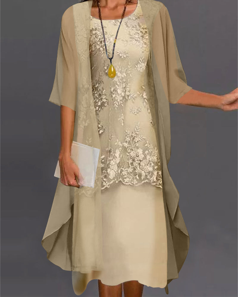 Woman wearing a beige dress with floral embellishments and a matching cardigan against a gray background