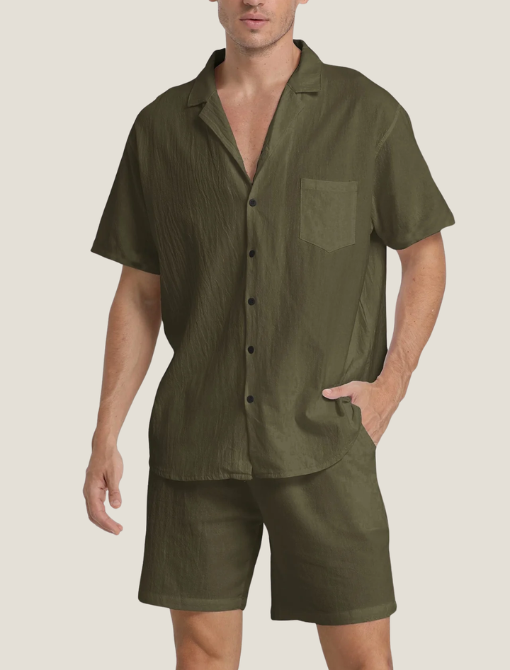 Man wearing an olive green shirt and shorts set on a plain background