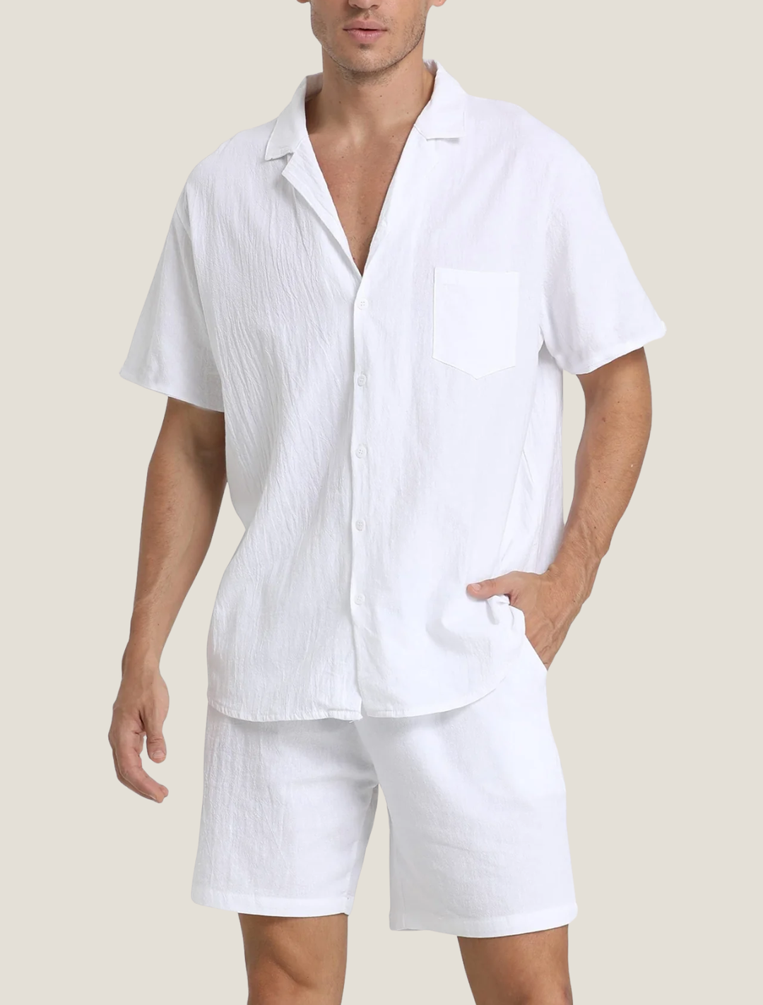 Man wearing a white linen shirt and shorts set on a plain background