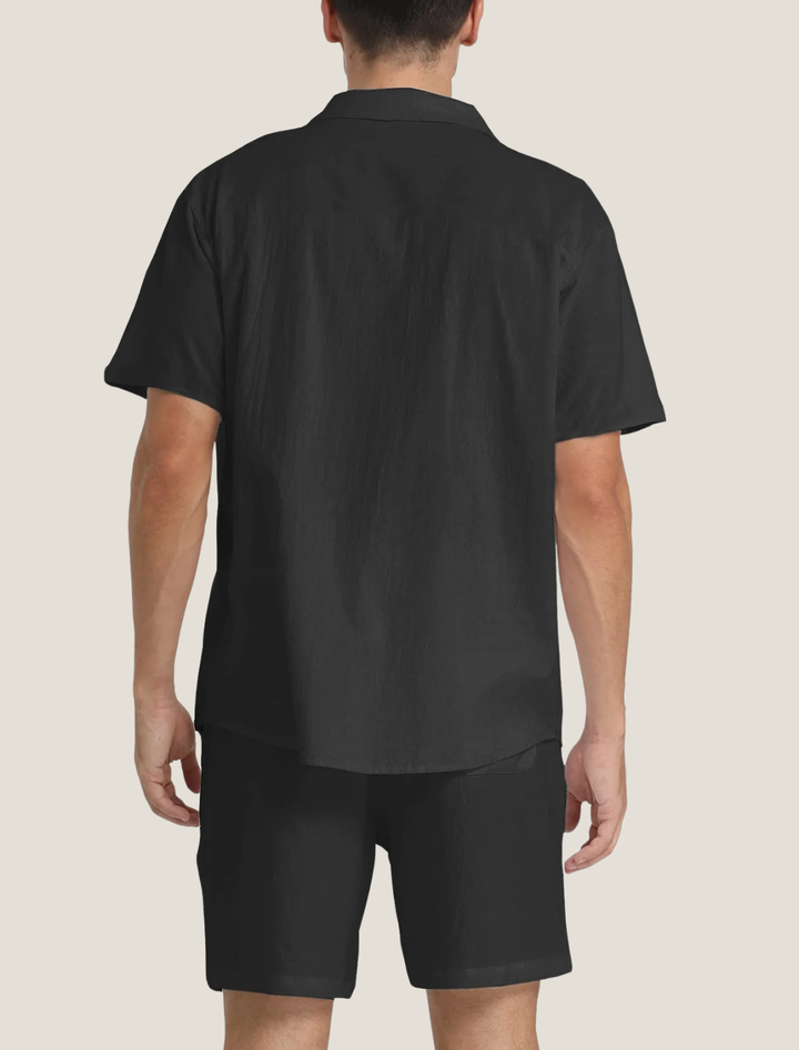 Person wearing a black shirt and shorts on a beige background