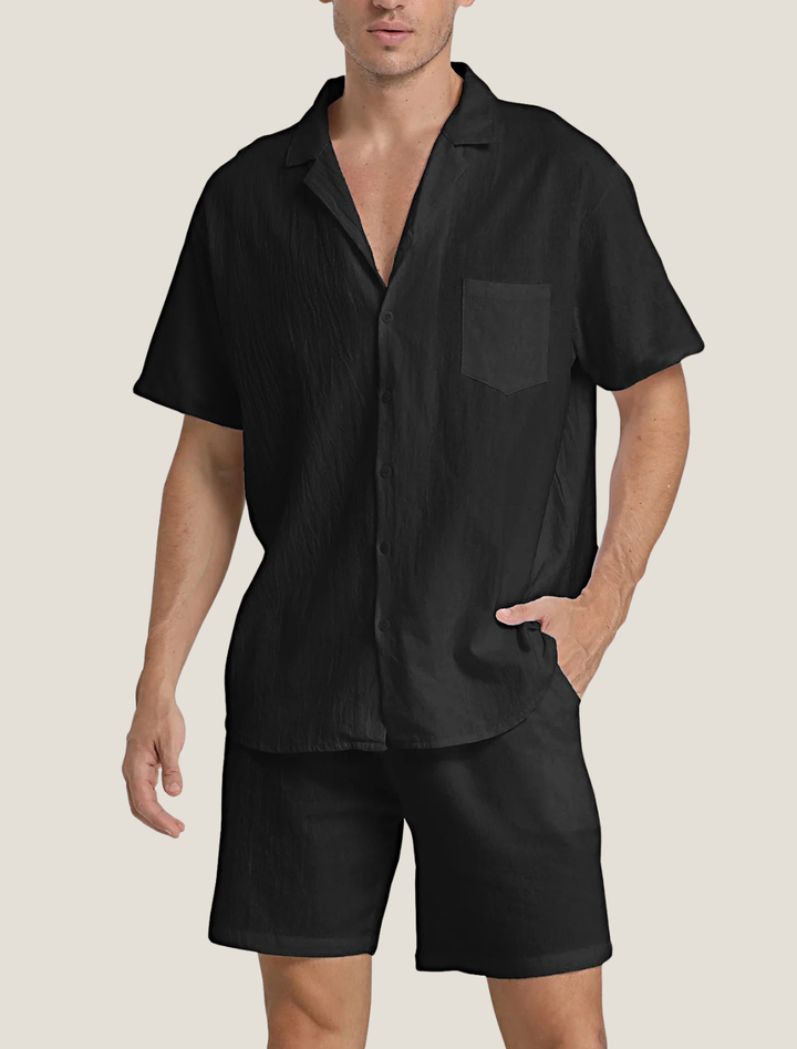 Man wearing a black short-sleeve shirt and shorts on a beige background