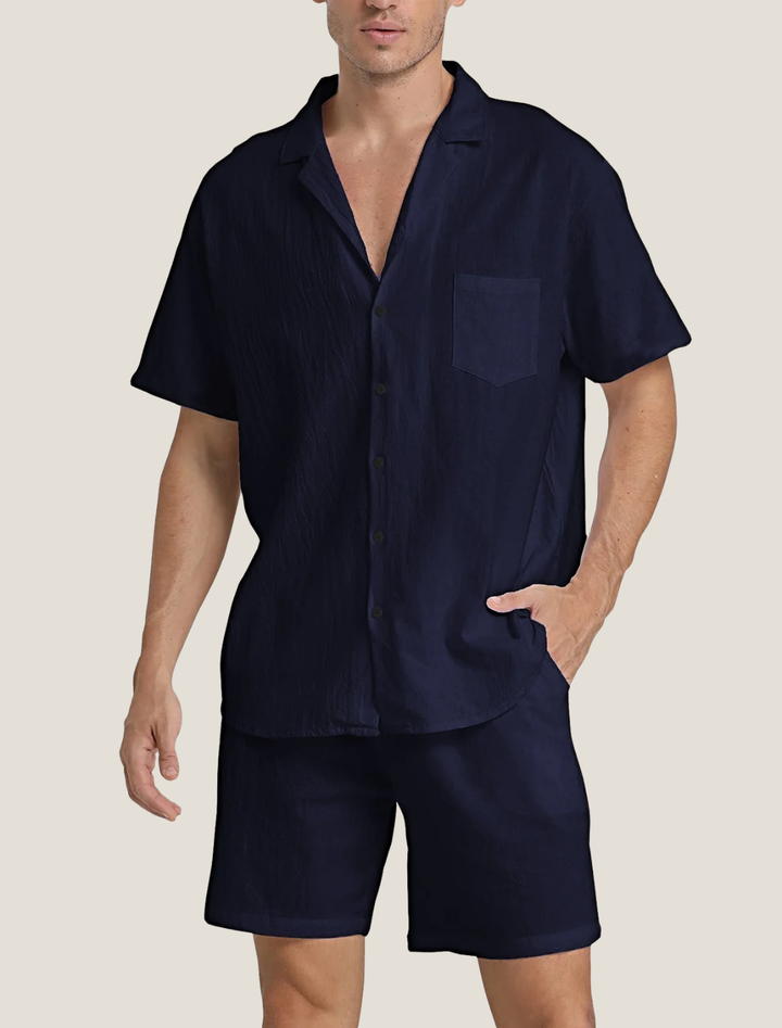 Man wearing a navy blue pajama set on a beige background