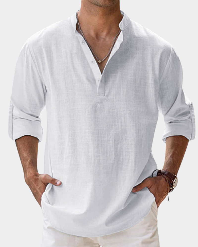 Man wearing a white long-sleeve shirt with rolled-up sleeves on a plain background
