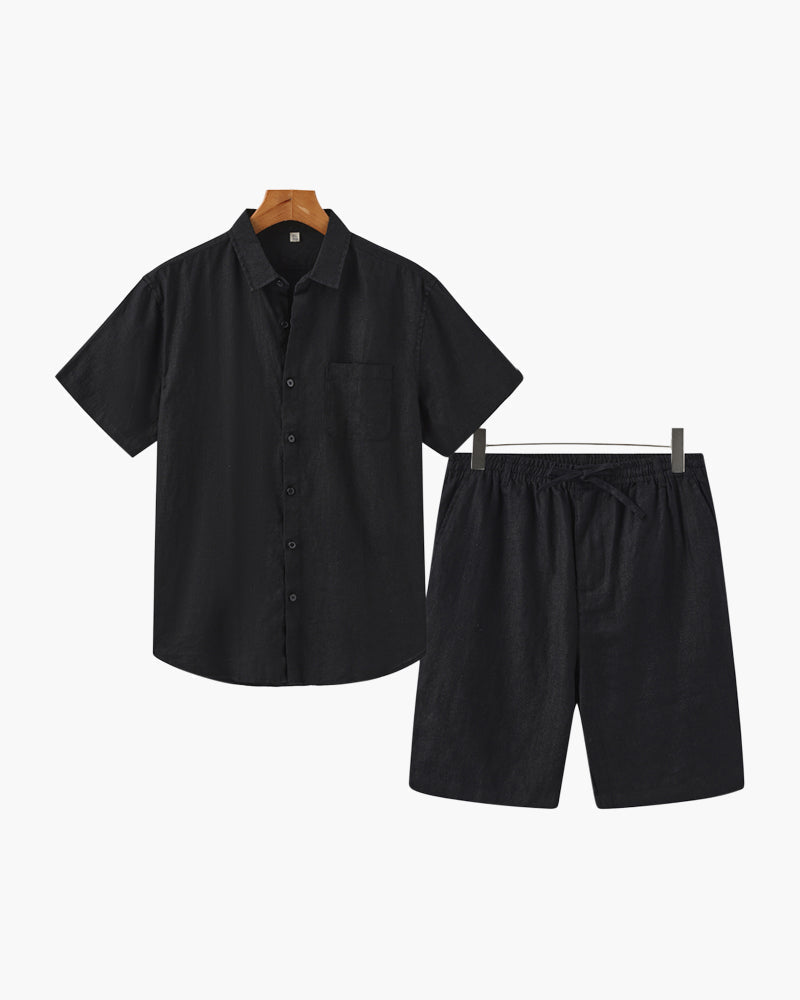 Black shirt and shorts set on hangers against a white background