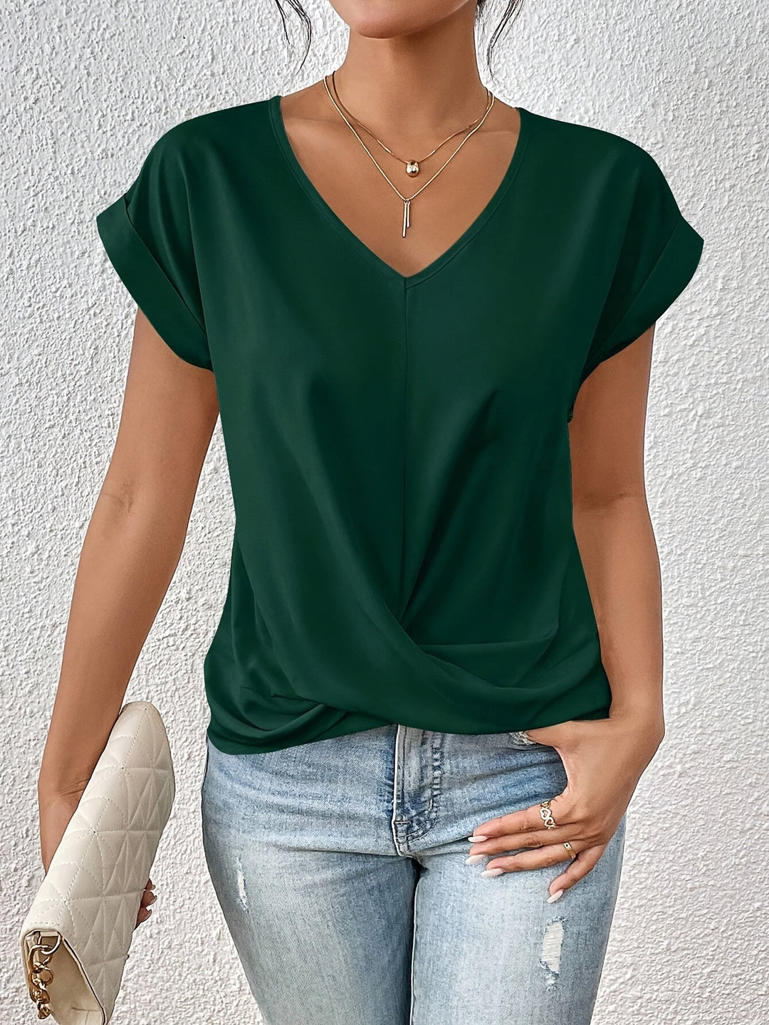 Person wearing a green top and blue jeans against a white background