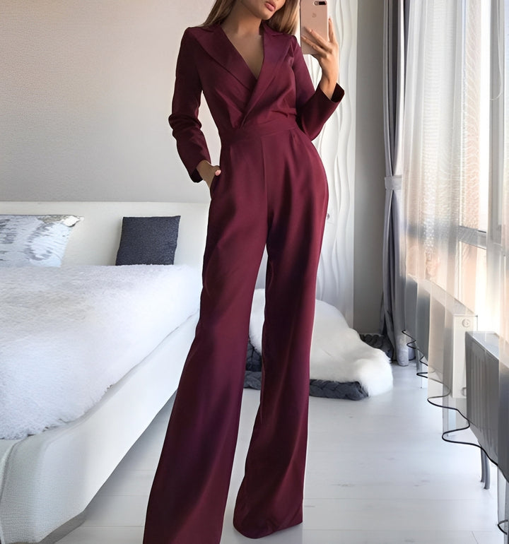 Person wearing a burgundy jumpsuit in a bedroom setting