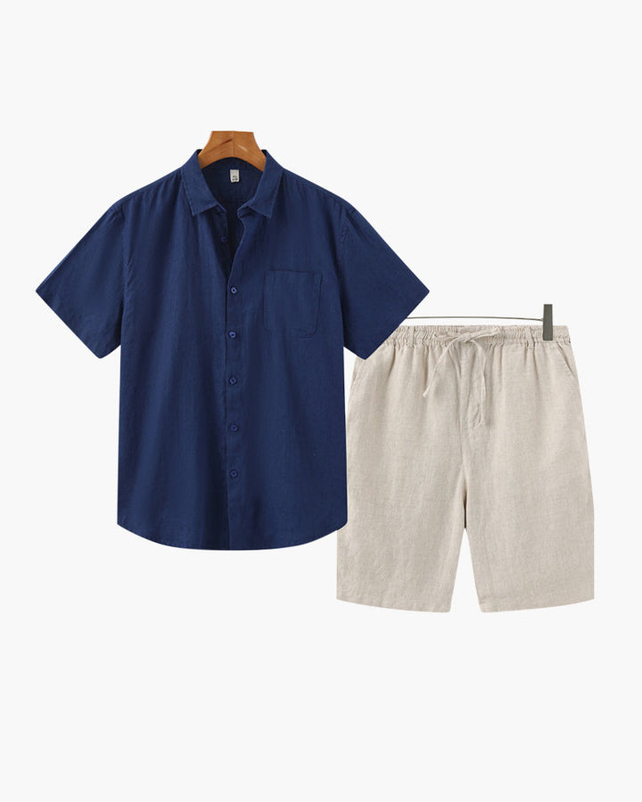 Navy shirt and beige shorts on hangers against a white background