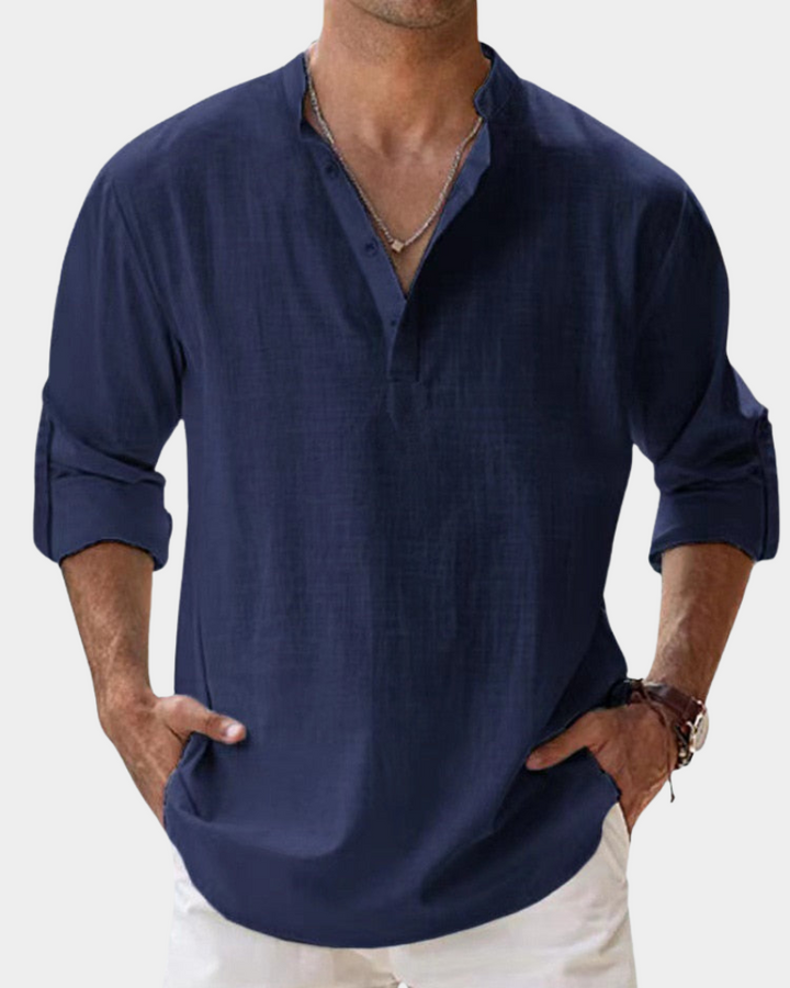 Man wearing a navy blue shirt with rolled-up sleeves on a white background