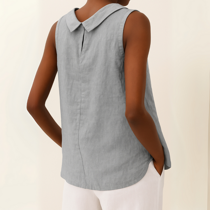 Light blue sleeveless blouse with a collar worn by a person on a beige background