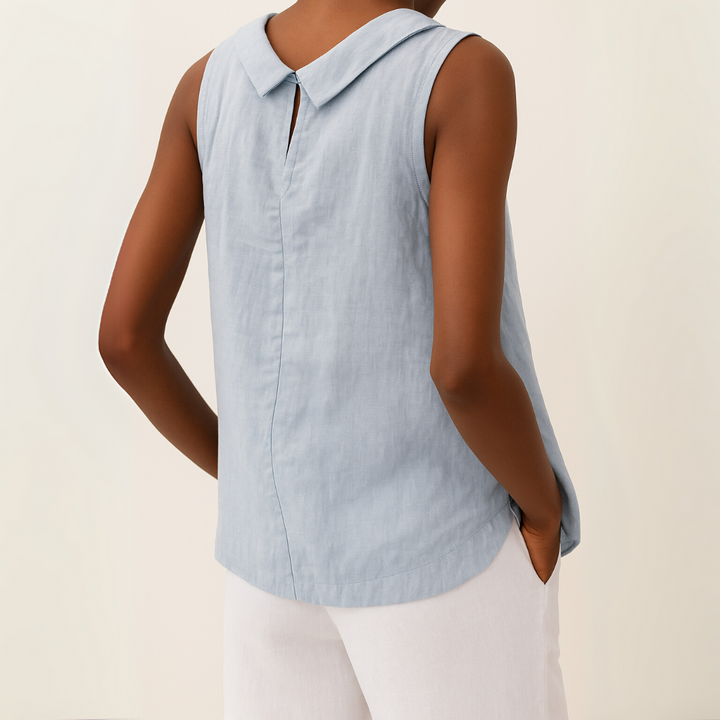 Light blue sleeveless top worn by a person on a beige background