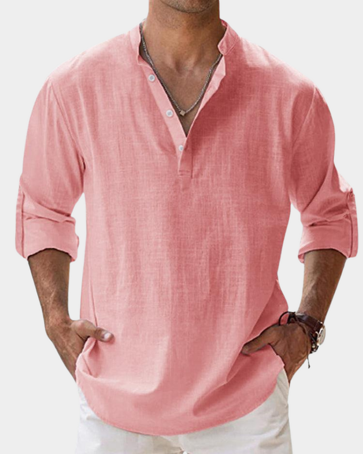 Man wearing a pink long-sleeve shirt with rolled-up sleeves on a white background