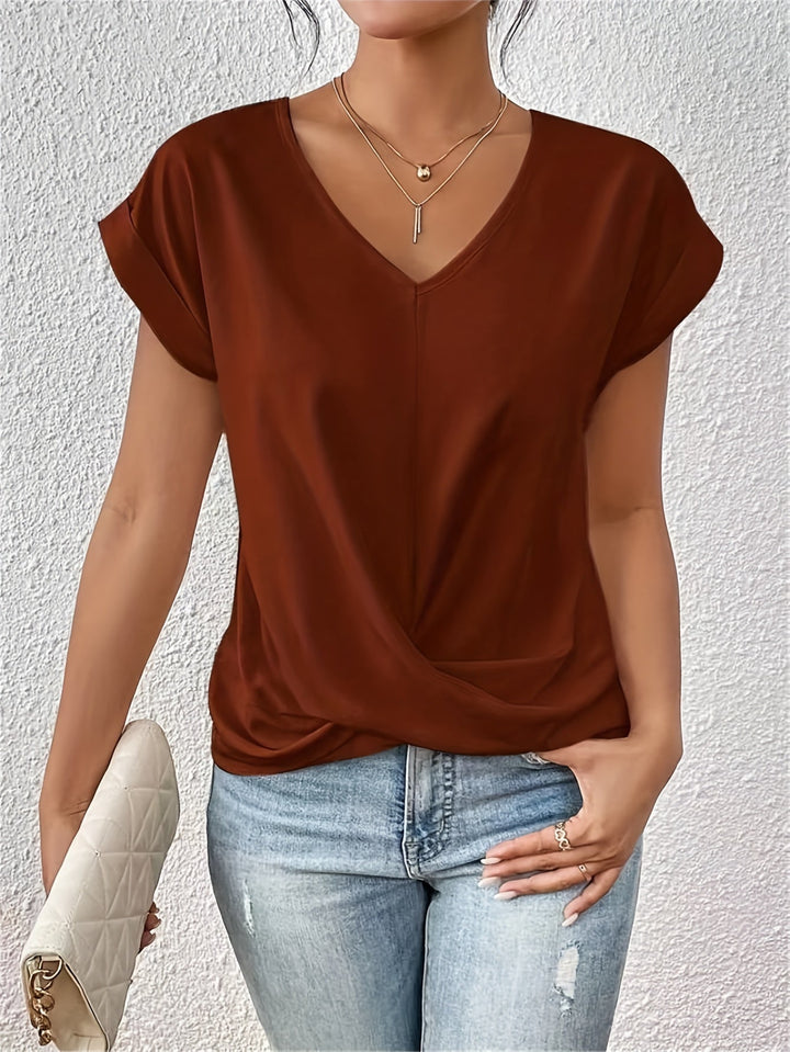 Woman wearing a brown top and blue jeans against a white background