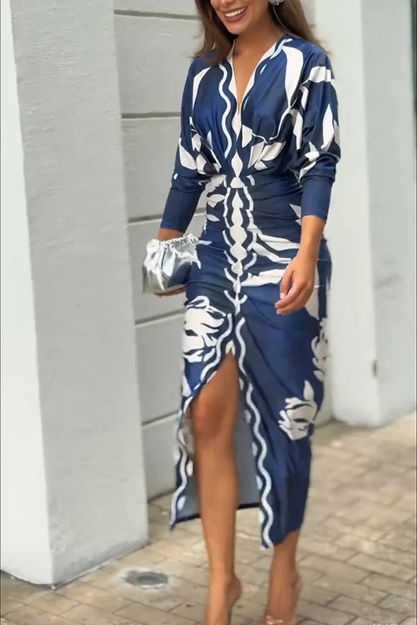 Woman wearing a blue and white patterned dress with a silver clutch.