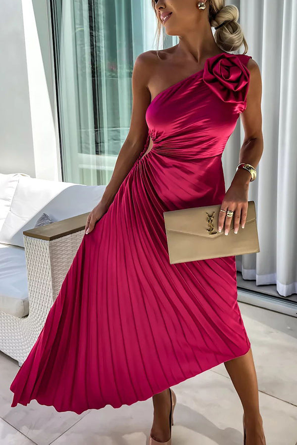 Woman in a pink one-shoulder dress holding a beige clutch indoors.