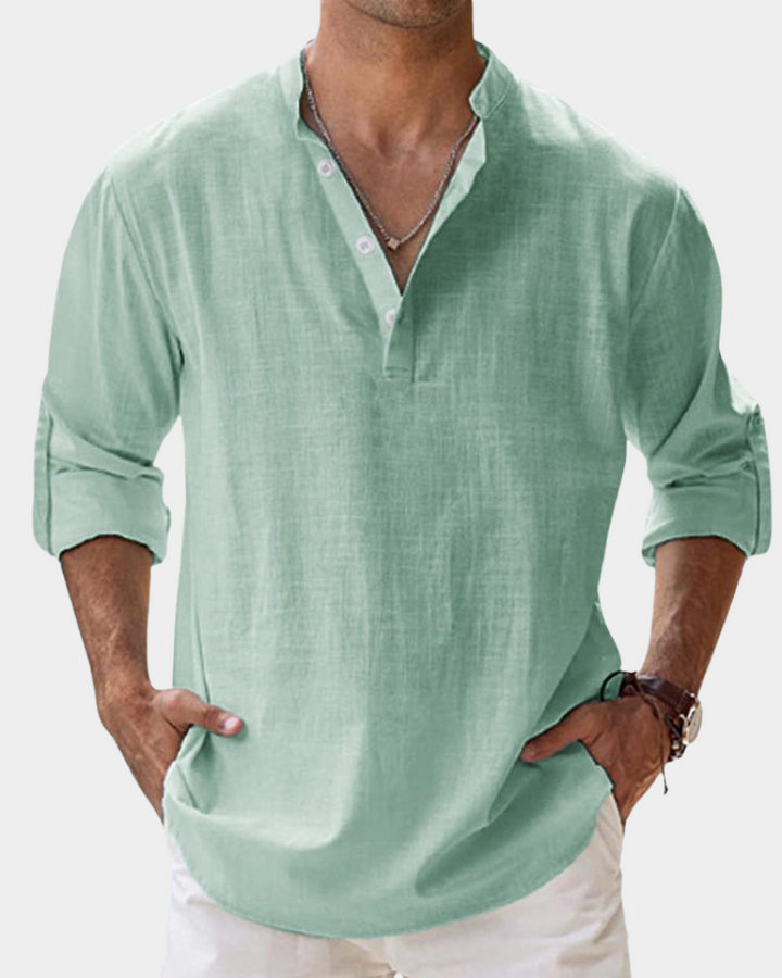 Man wearing a light green shirt with rolled-up sleeves on a white background