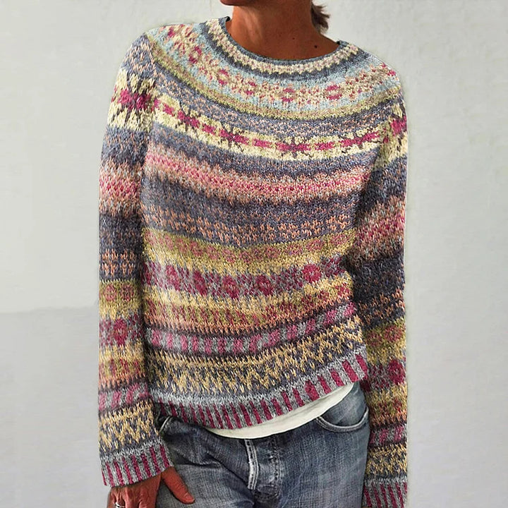 Multicolored patterned sweater worn by a person on a plain background