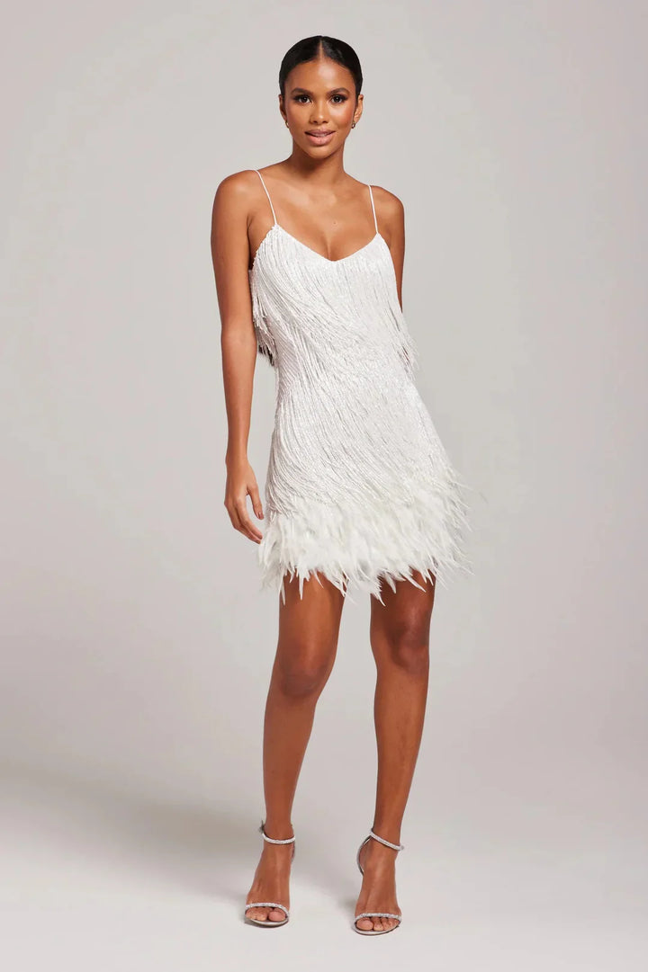 Woman wearing a white feathered dress on a plain background