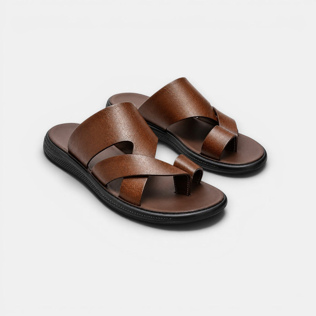 Pair of brown sandals with black soles on a light gray background