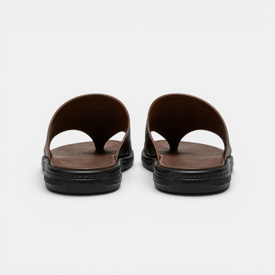 Pair of brown sandals with black soles on a white background