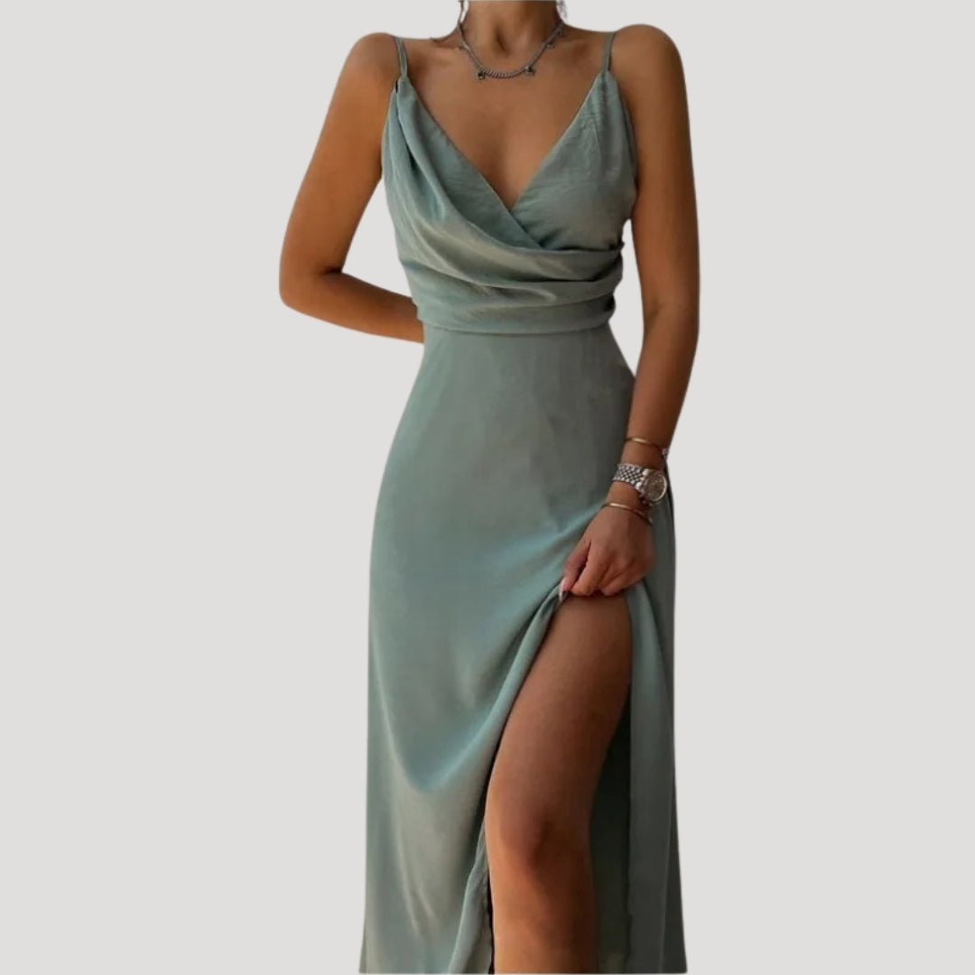 Green evening gown with a slit on a plain background
