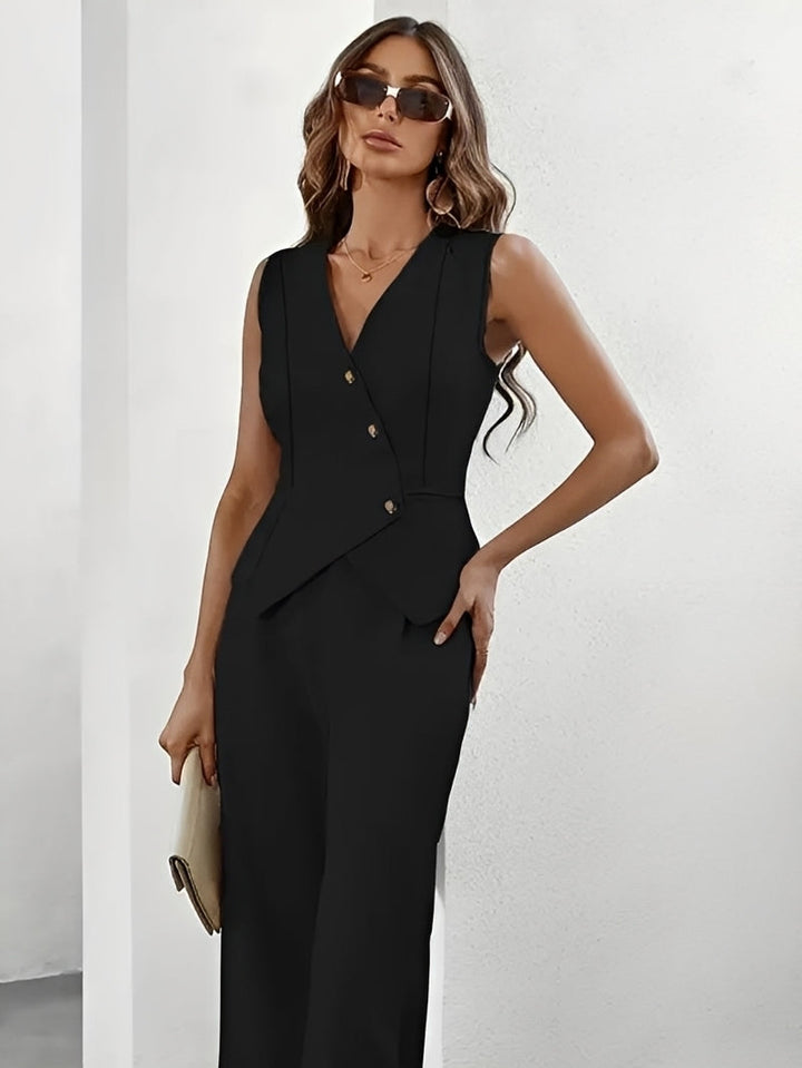 Woman wearing a black sleeveless blazer and pants against a white background