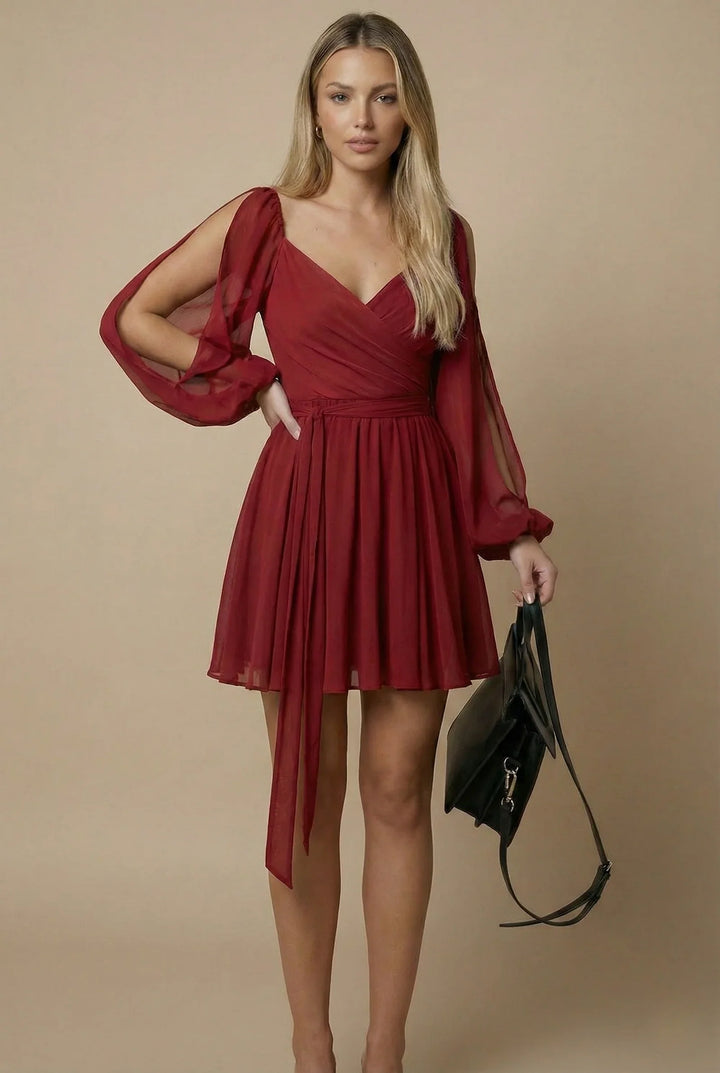 Woman wearing a red dress holding a black handbag against a beige background