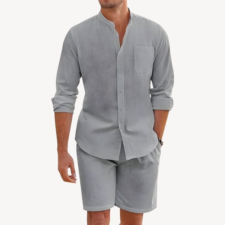 Man wearing a gray long-sleeve shirt and shorts set on a white background