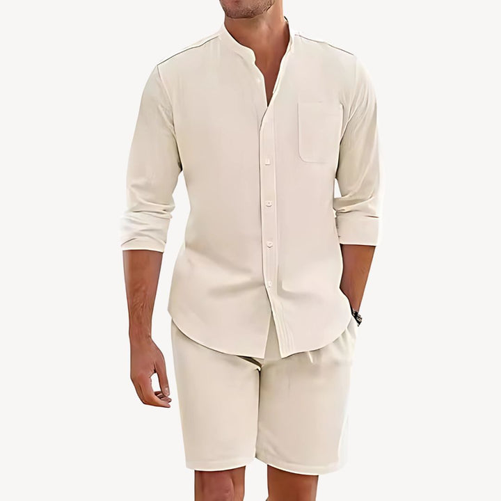 Man wearing a beige button-up shirt and shorts on a white background