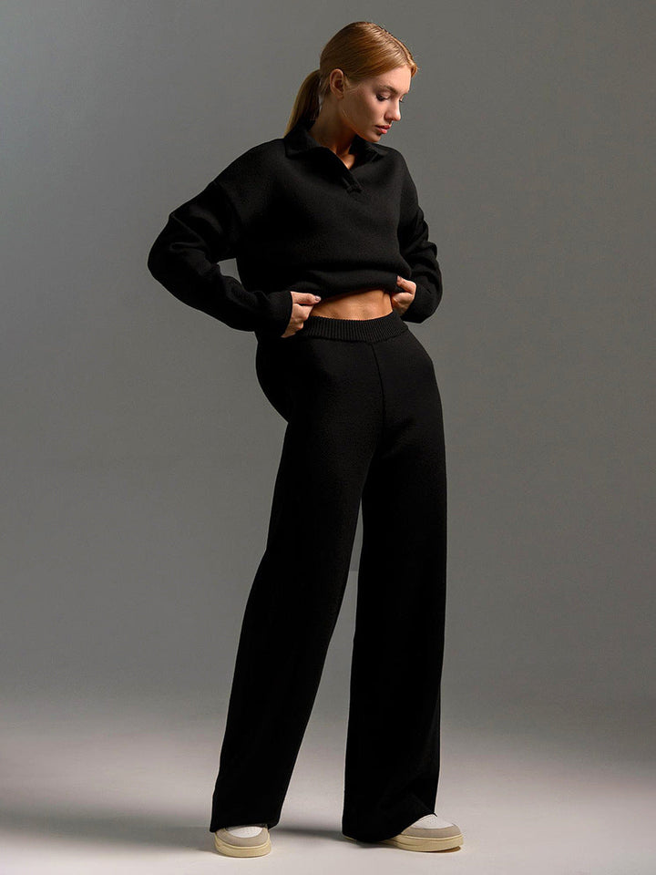 Person wearing a black outfit against a gray background