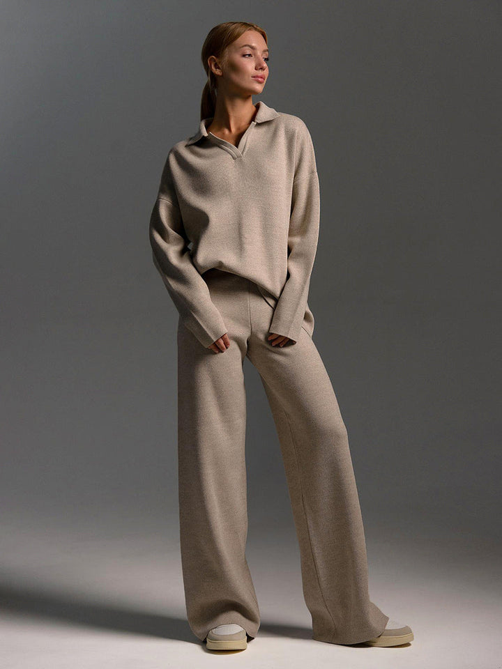 Woman wearing a beige sweater and pants set against a gray background