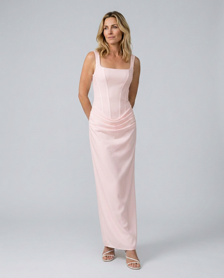 Woman wearing a pink dress against a plain background