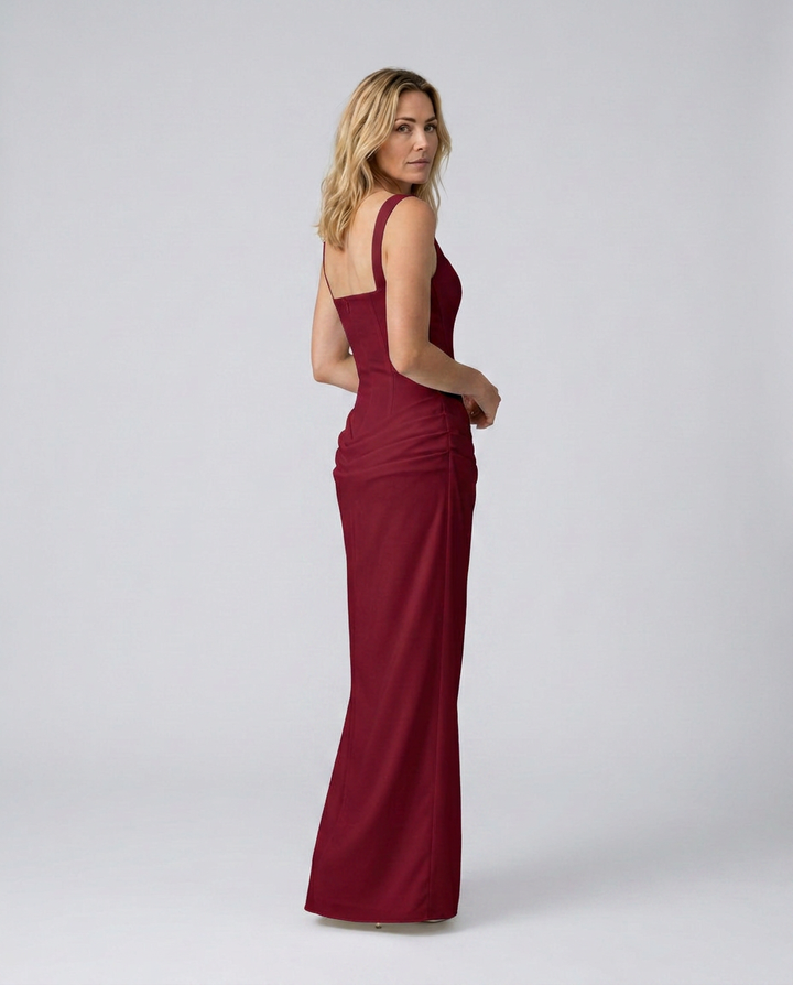 Woman wearing a burgundy evening gown on a white background