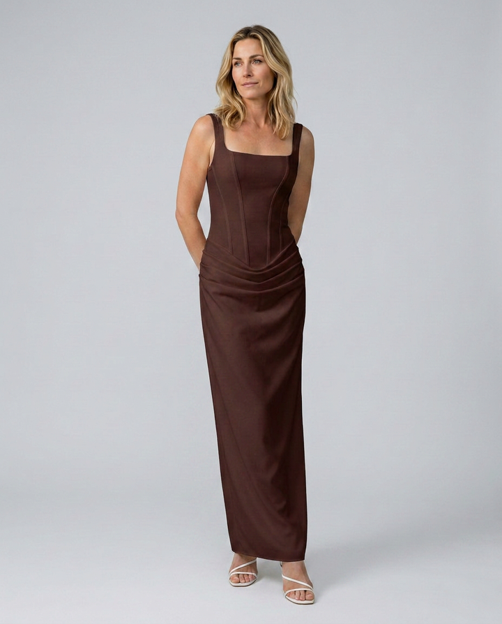 Woman wearing a brown evening gown against a plain background
